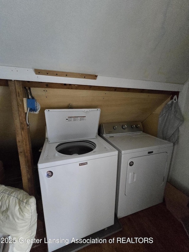 laundry area featuring wood walls, laundry area, and washing machine and clothes dryer