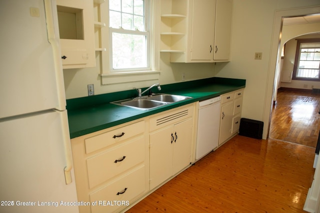 kitchen with white appliances, open shelves, a sink, light wood-style floors, and dark countertops