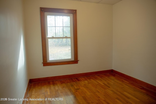 unfurnished room featuring hardwood / wood-style flooring and baseboards