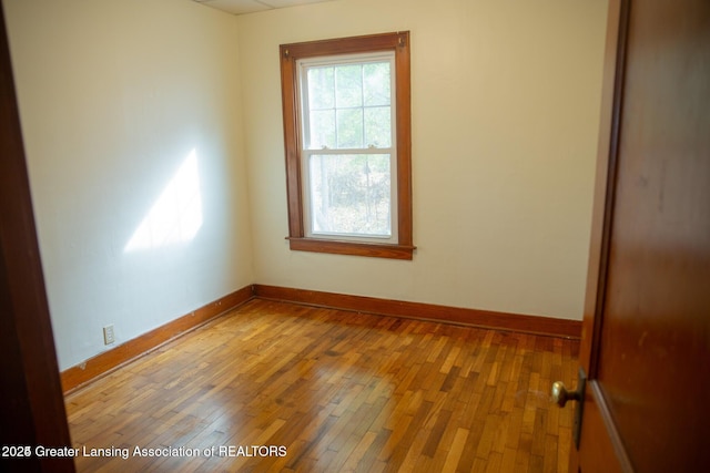 empty room with baseboards and light wood-style flooring