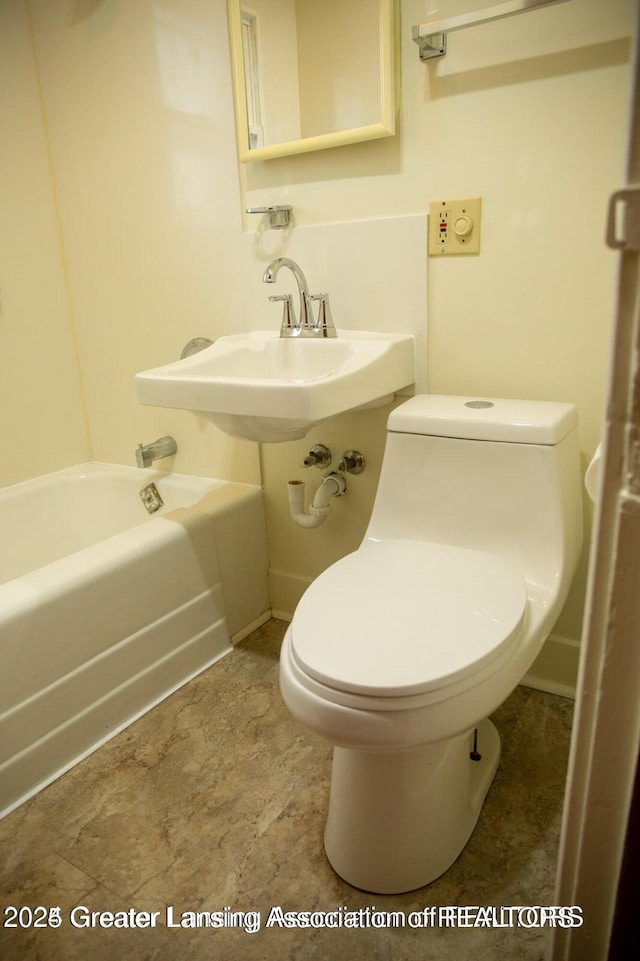 bathroom with toilet and a washtub