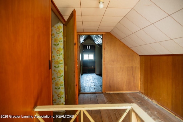 bonus room featuring hardwood / wood-style floors, vaulted ceiling, and wooden walls