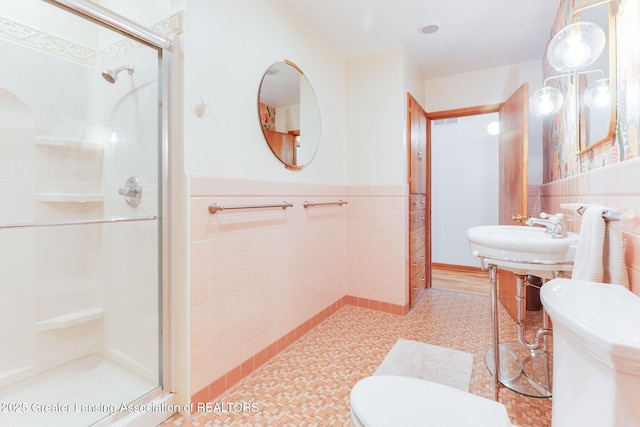 bathroom featuring wainscoting, a shower stall, and toilet