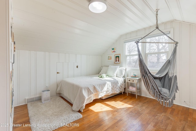 bedroom featuring lofted ceiling, light wood-style floors, and visible vents