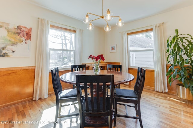 dining room with light wood finished floors, a notable chandelier, and a healthy amount of sunlight