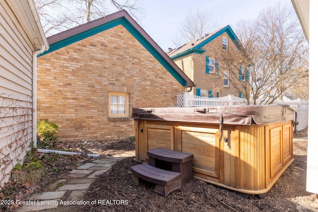 exterior space featuring a hot tub and fence