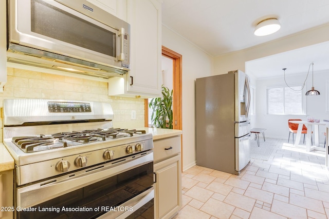 kitchen with decorative backsplash, appliances with stainless steel finishes, light countertops, and crown molding