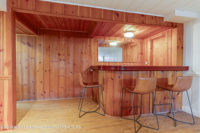 bar with wood finished floors, wooden walls, a dry bar, and wooden ceiling