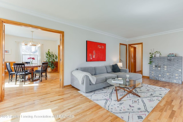 living room with a chandelier, crown molding, baseboards, and wood finished floors