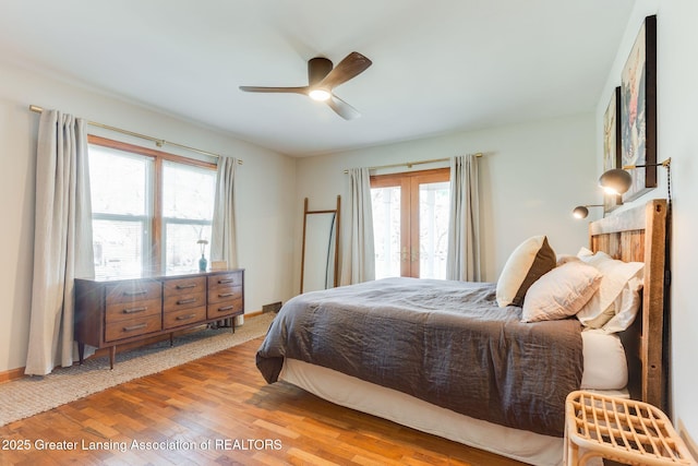 bedroom featuring french doors, wood finished floors, and a ceiling fan