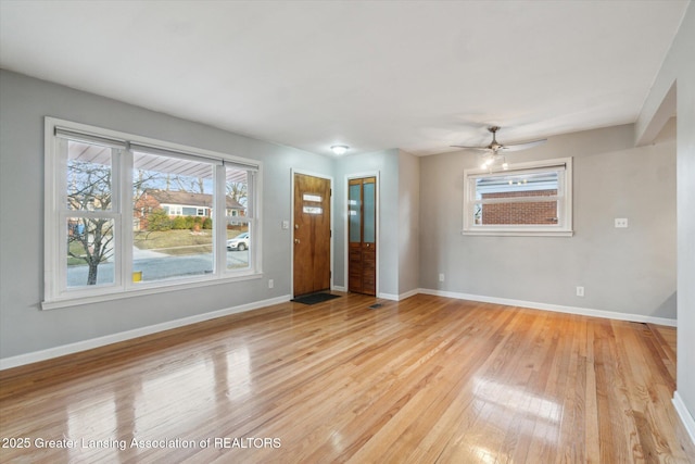 interior space featuring baseboards, light wood-type flooring, and ceiling fan