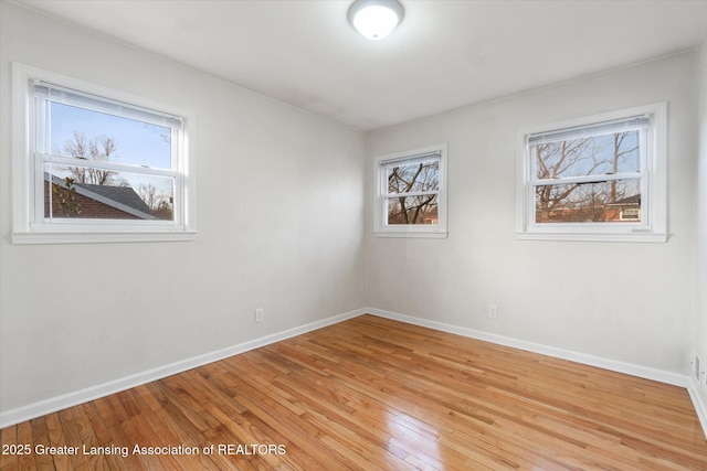 empty room with light wood-type flooring and baseboards