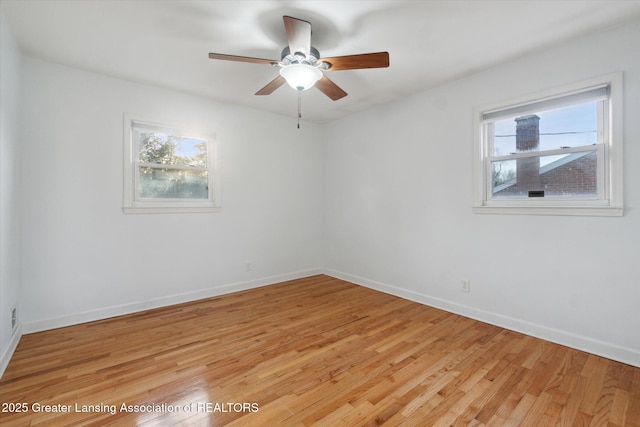 empty room with a ceiling fan, a healthy amount of sunlight, light wood-type flooring, and baseboards