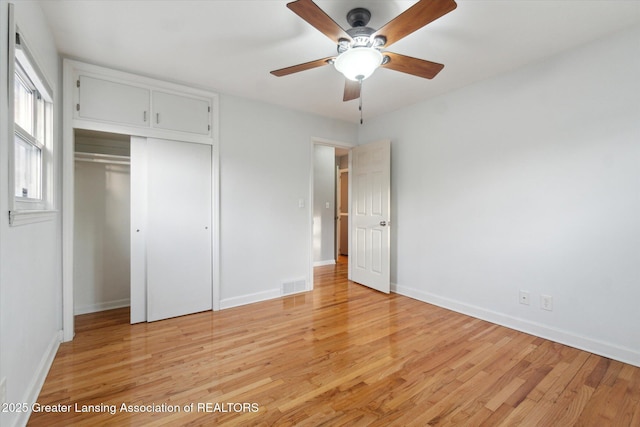 unfurnished bedroom featuring light wood finished floors, visible vents, baseboards, and a closet