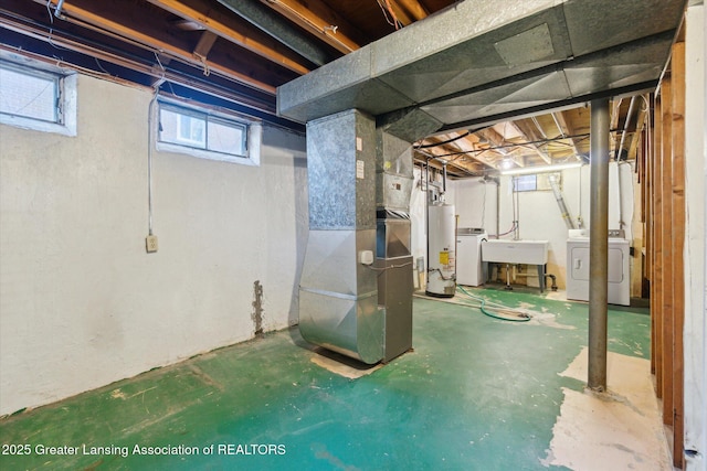 basement featuring gas water heater, heating unit, separate washer and dryer, and a sink