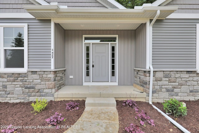 3427 W Broadmoor Dr, Lansing, MI 48906 - entrance to property featuring stone siding, covered porch, and board and batten siding