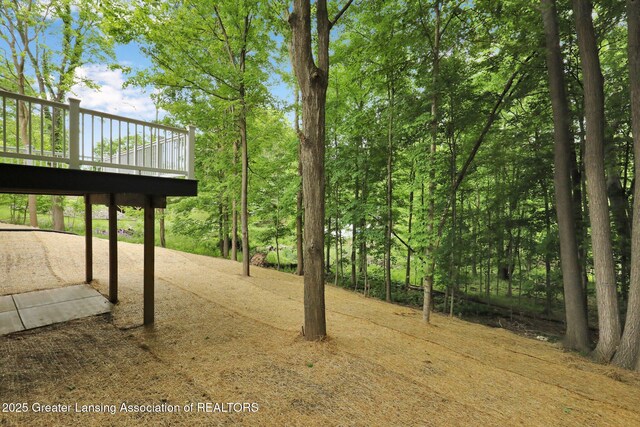 3427 W Broadmoor Dr, Lansing, MI 48906 - view of yard featuring a wooden deck and a patio