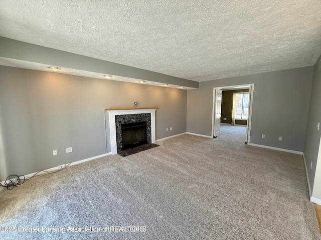 unfurnished living room with baseboards, carpet, and a high end fireplace