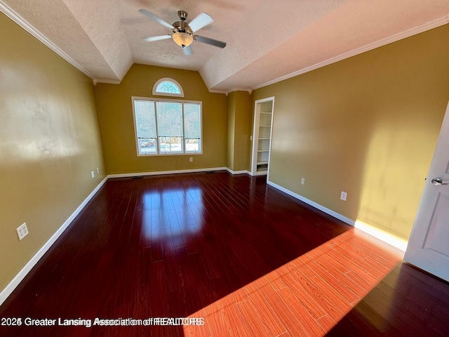 unfurnished room featuring wood finished floors, baseboards, lofted ceiling, ceiling fan, and a textured ceiling