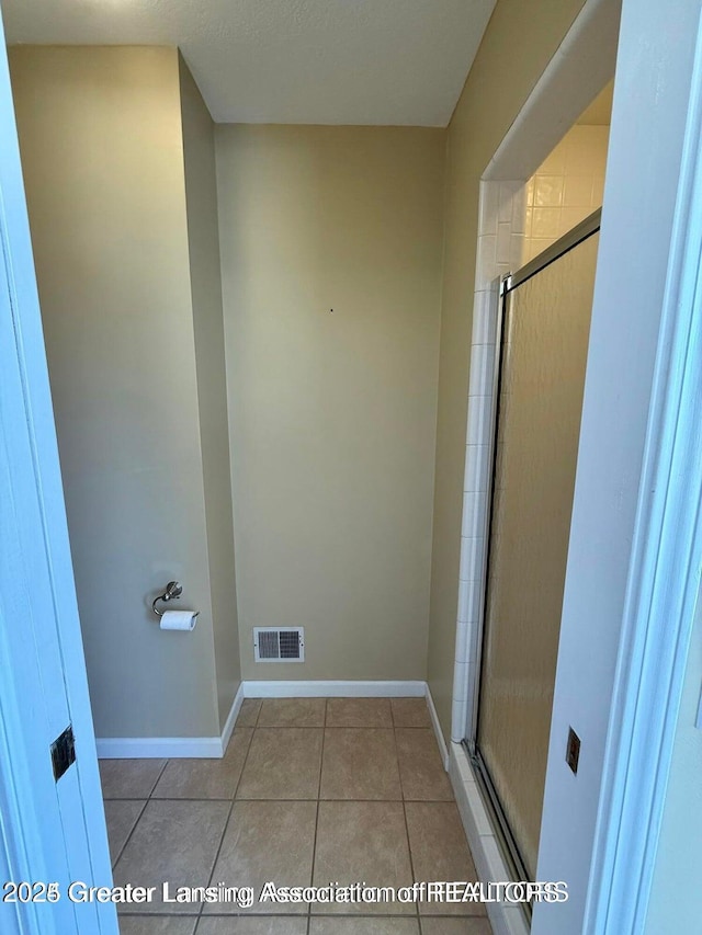 full bath with tile patterned floors, visible vents, baseboards, and a shower stall