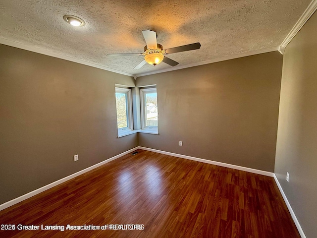 empty room with a ceiling fan, baseboards, dark wood-type flooring, a textured ceiling, and crown molding