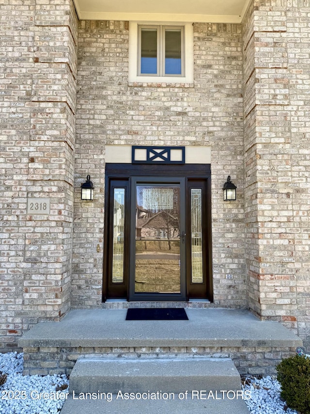 doorway to property featuring brick siding