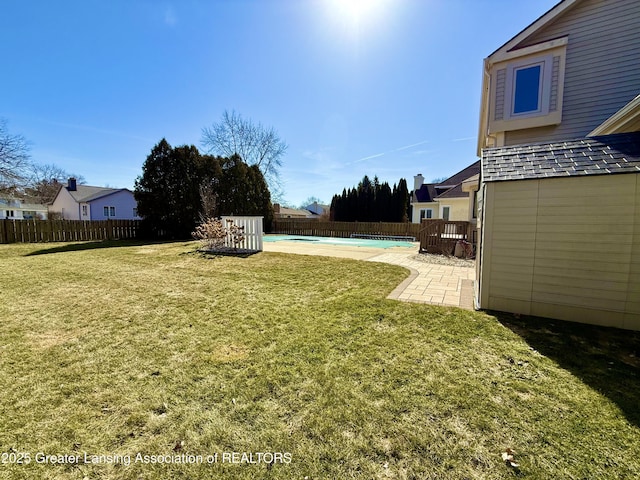 view of yard with a fenced in pool, an outdoor structure, a fenced backyard, a patio area, and a storage unit