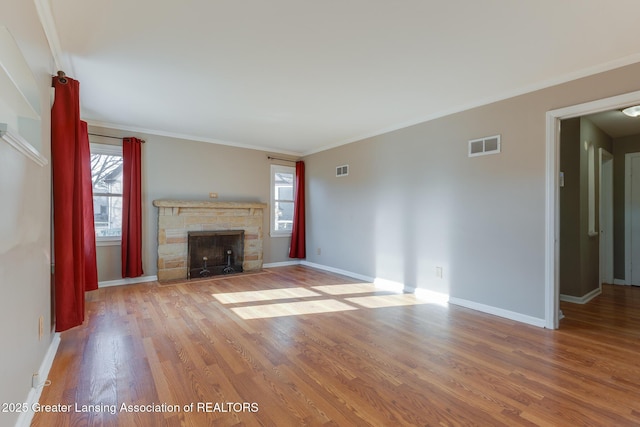 unfurnished living room with baseboards, wood finished floors, visible vents, and ornamental molding