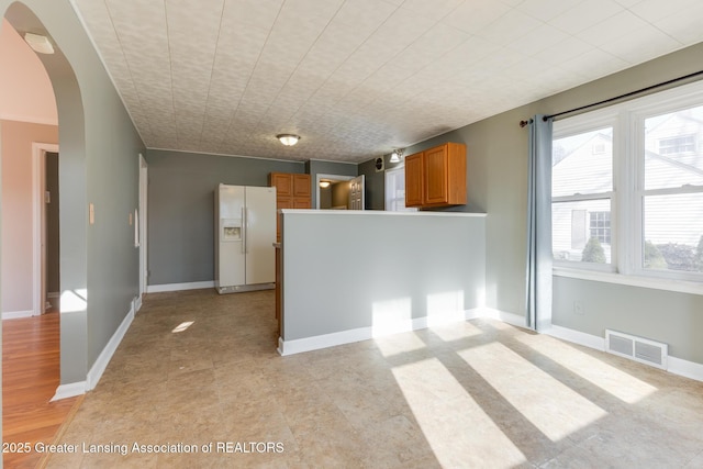 interior space with visible vents, arched walkways, and baseboards