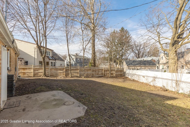 view of yard featuring a residential view, a fenced backyard, and a patio area