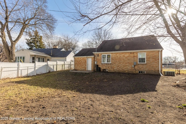 rear view of property featuring brick siding, central AC, and fence