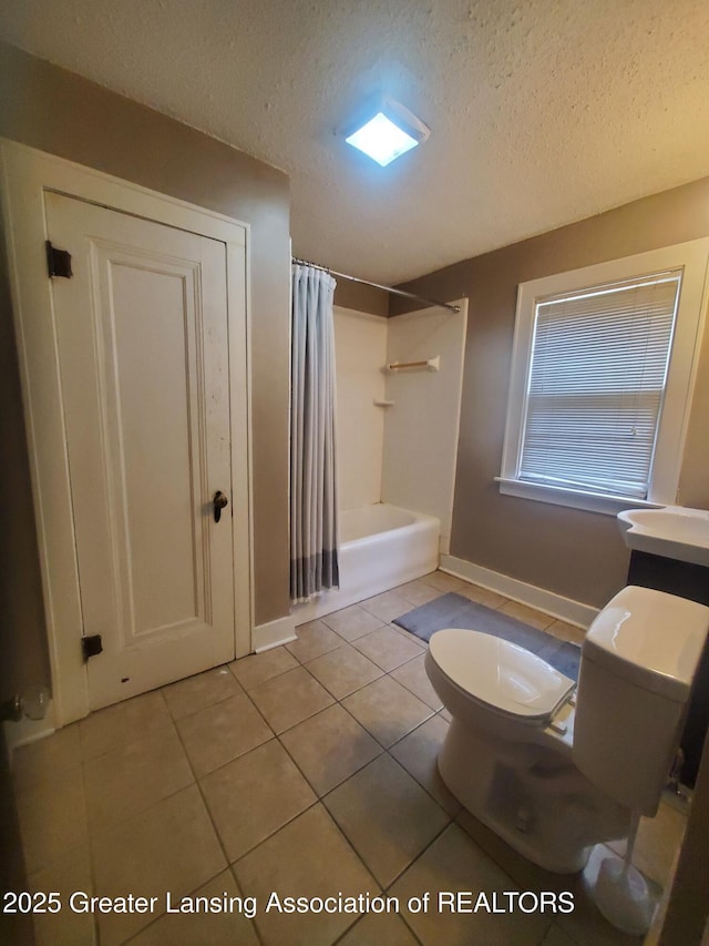 bathroom with tile patterned floors, shower / bath combo with shower curtain, toilet, a textured ceiling, and baseboards