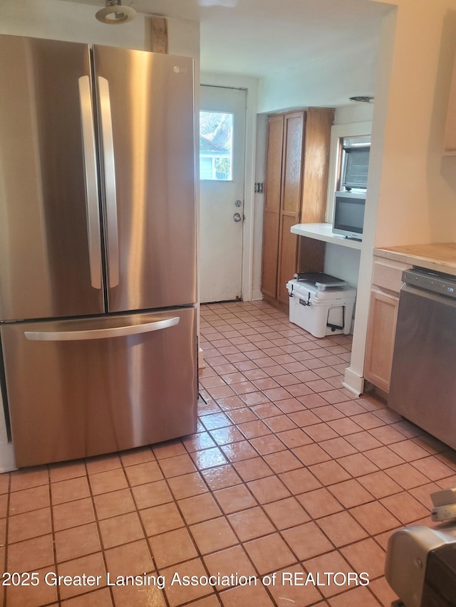 kitchen featuring light tile patterned floors, appliances with stainless steel finishes, and light countertops