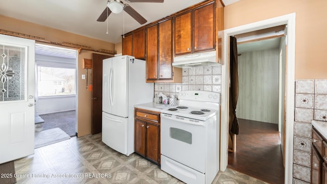 kitchen featuring white appliances, brown cabinetry, ceiling fan, light countertops, and under cabinet range hood