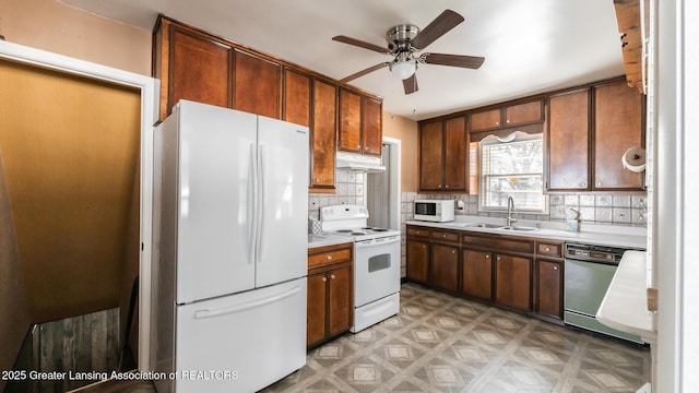 kitchen with ceiling fan, under cabinet range hood, light floors, white appliances, and a sink