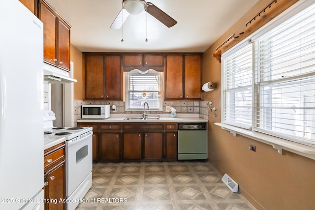 kitchen featuring white appliances, ceiling fan, a sink, light countertops, and under cabinet range hood