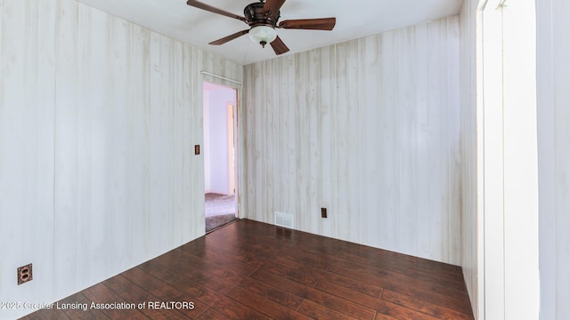 unfurnished room with hardwood / wood-style floors, visible vents, and ceiling fan