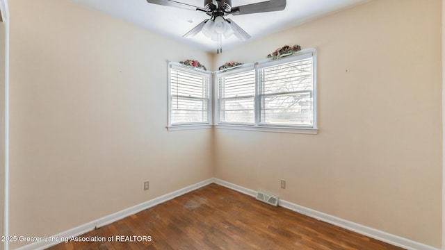 empty room with visible vents, baseboards, dark wood-type flooring, and ceiling fan