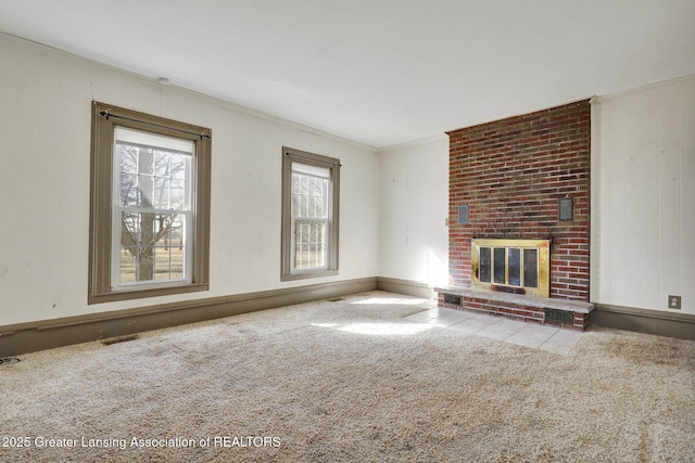 unfurnished living room with crown molding, a fireplace, visible vents, and carpet floors