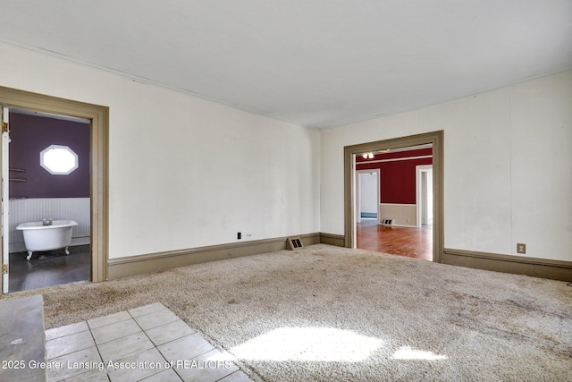 tiled spare room featuring carpet floors