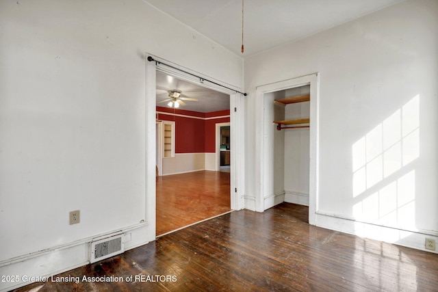 unfurnished bedroom featuring visible vents, wood-type flooring, and a closet