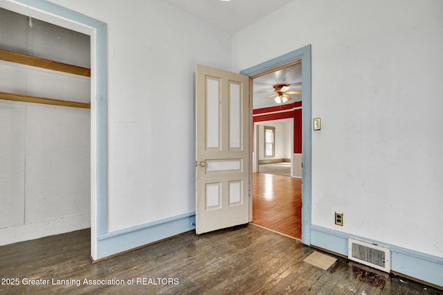 unfurnished bedroom with visible vents, a closet, and hardwood / wood-style floors