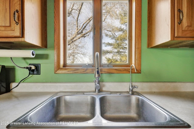 details with light countertops, brown cabinets, and a sink