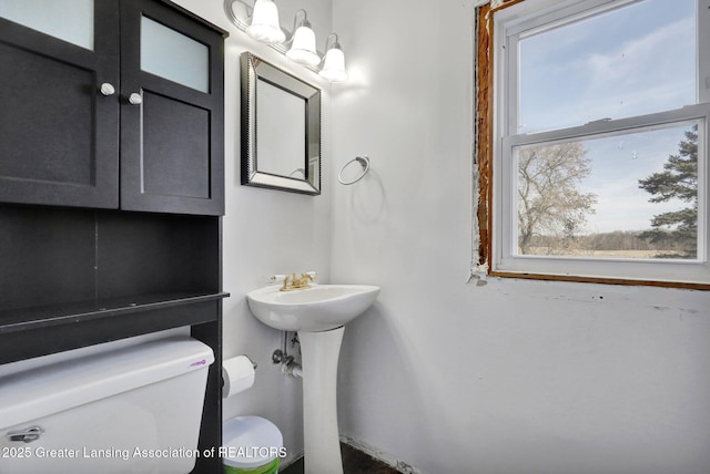 half bathroom featuring toilet and a sink