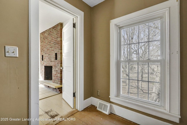 corridor featuring light wood-style floors, visible vents, and baseboards