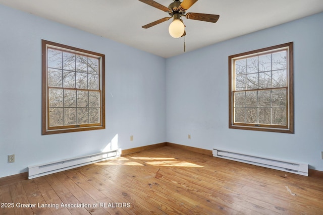 spare room with baseboards, a baseboard heating unit, a ceiling fan, and wood-type flooring