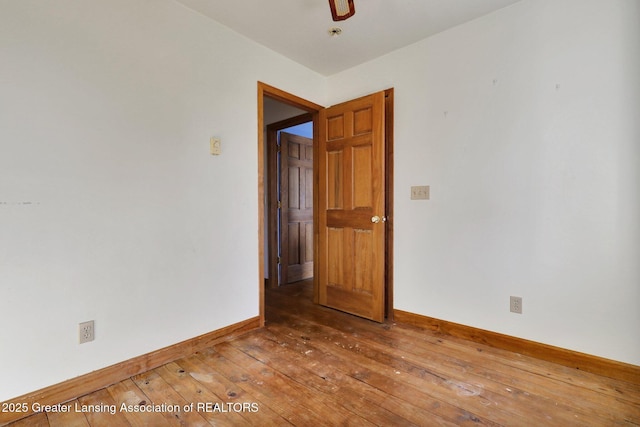 empty room with hardwood / wood-style flooring and baseboards