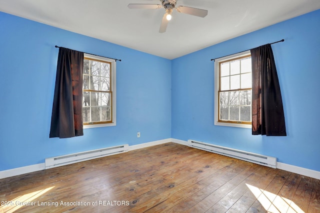 empty room with a baseboard radiator, baseboards, hardwood / wood-style floors, and a ceiling fan