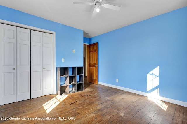 unfurnished bedroom featuring a closet, baseboards, and wood-type flooring