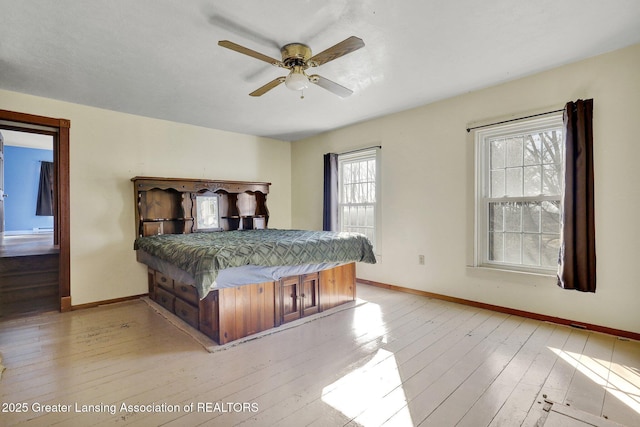 bedroom featuring light wood-style flooring, baseboards, and ceiling fan